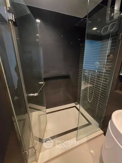 Modern bathroom with sleek glass shower enclosure and contemporary design.