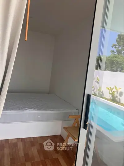 Cozy bedroom with pool view, featuring a minimalist design and wooden flooring, perfect for relaxation.