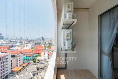 High-rise balcony with city view and air conditioning units, perfect for urban living.