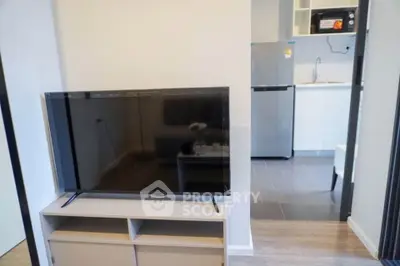 Modern living room with sleek TV and open kitchen layout