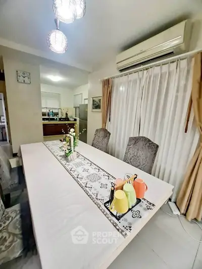 Elegant dining area with stylish decor and modern kitchen in open layout apartment.