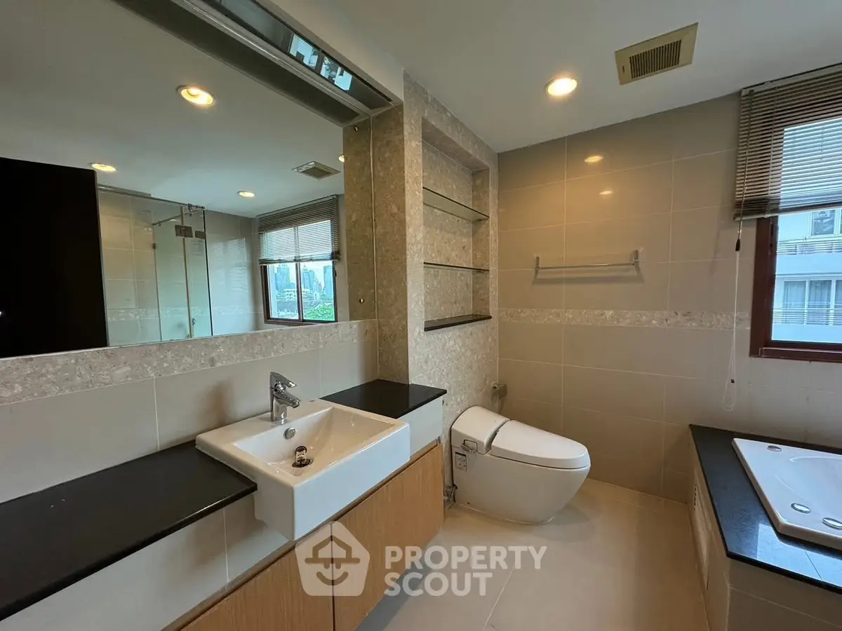 Modern bathroom with sleek fixtures and large mirror in a stylish apartment.