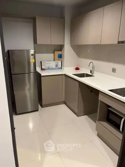 Modern kitchen with sleek cabinetry and stainless steel appliances in a stylish apartment.