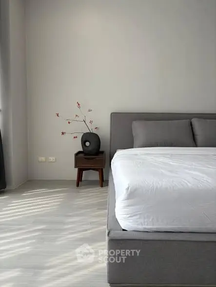 Modern minimalist bedroom with gray bed and stylish decor