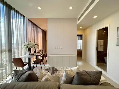 Luxurious modern living room with floor-to-ceiling windows and elegant dining area