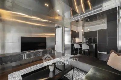 Luxurious modern living room with sleek metallic finishes and open kitchen layout.