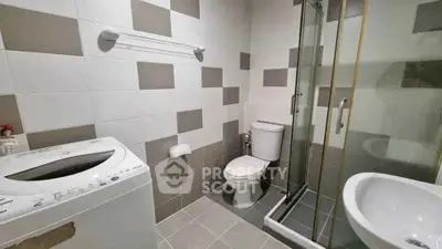 Modern bathroom with washing machine and glass shower enclosure