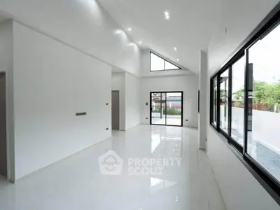 Spacious modern living room with high ceilings and large windows for natural light.