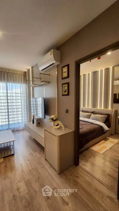 Modern living room with stylish decor and view into cozy bedroom