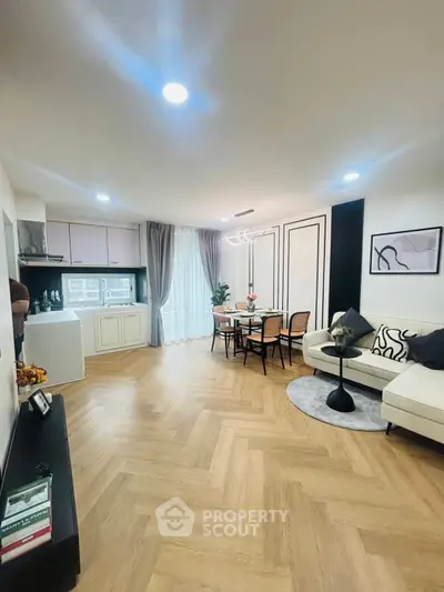 Stylish open-plan living room with modern kitchen and elegant dining area.