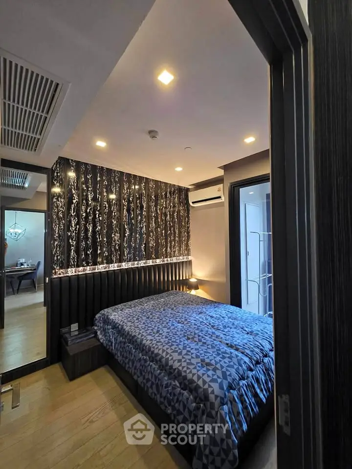 Modern bedroom with stylish wallpaper and cozy lighting in a contemporary apartment.