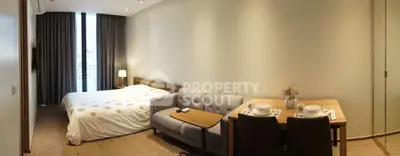 Modern studio apartment with cozy bed, stylish sofa, and dining area.