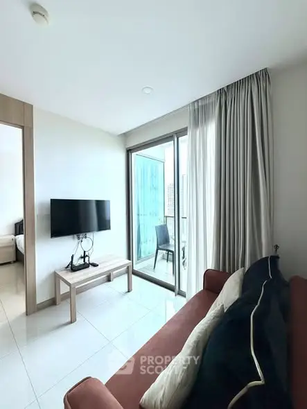 Modern living room with balcony access and sleek furnishings in a bright apartment.