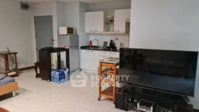 Cozy living room with compact kitchen and modern appliances