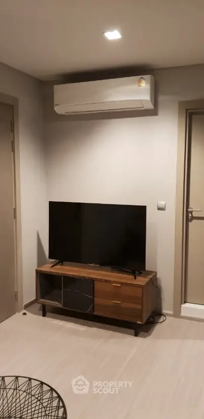 Modern living room with sleek TV stand and air conditioning unit, perfect for cozy entertainment.