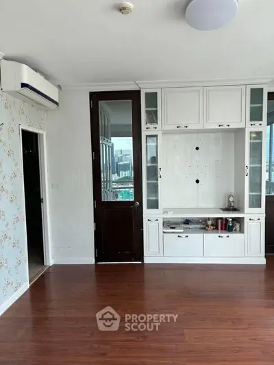 Spacious living room with wooden flooring and built-in storage unit
