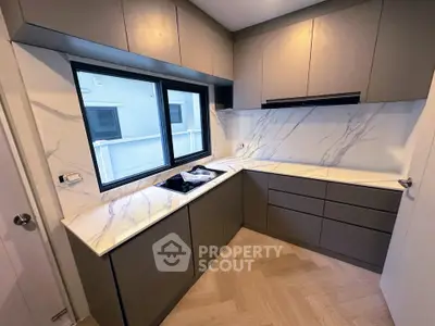 Modern kitchen with sleek cabinetry and marble countertops in a contemporary home.