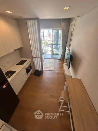 Modern studio apartment with open kitchen and balcony view