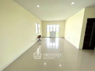 Spacious empty living room with large windows and glossy tiled floors