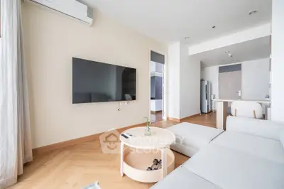 Modern living room with sleek TV and cozy seating in a stylish apartment.