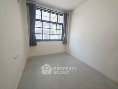 Bright empty room with large window and gray curtains, perfect for customization.