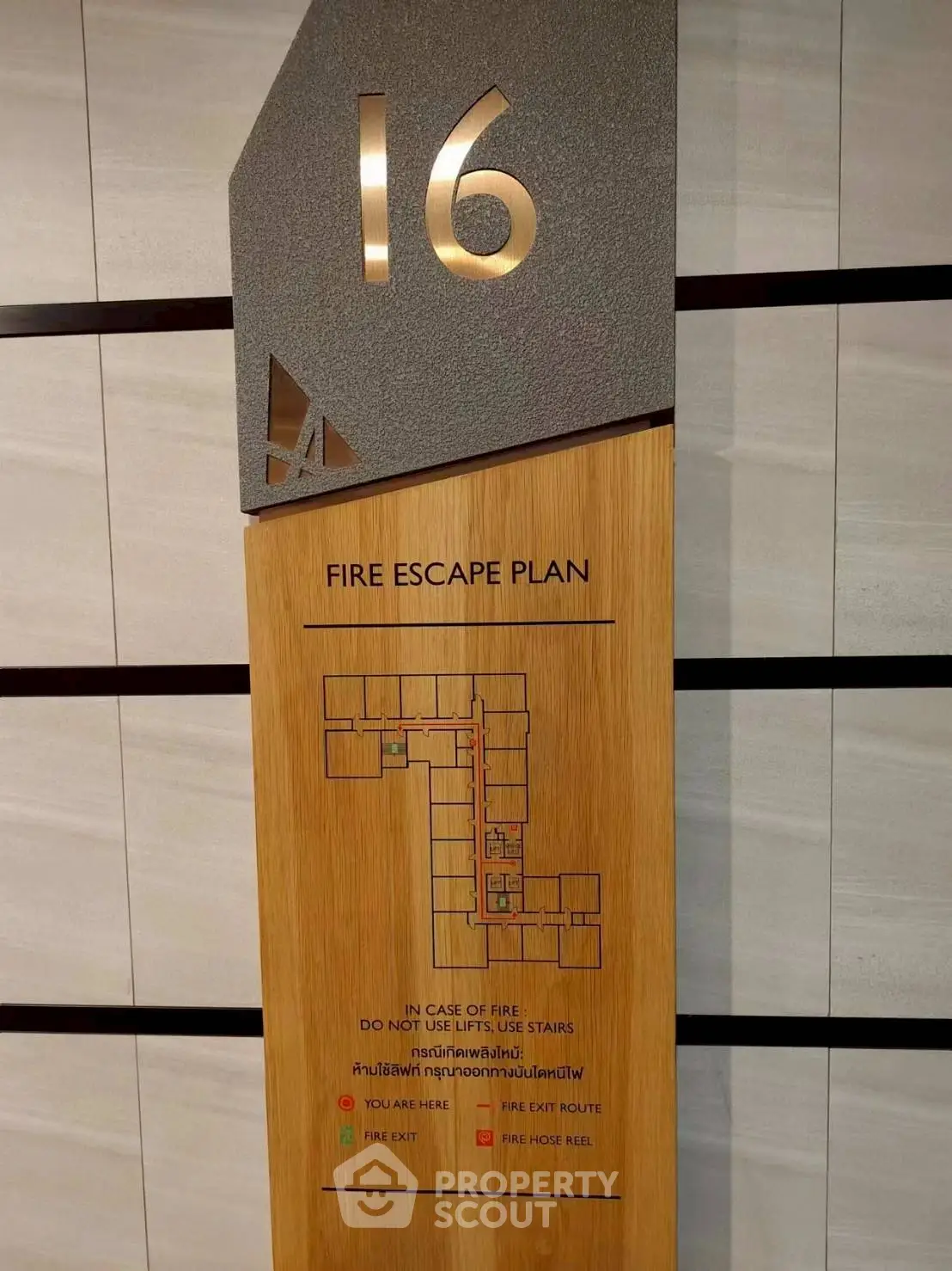 Modern fire escape plan on wooden panel in high-rise building