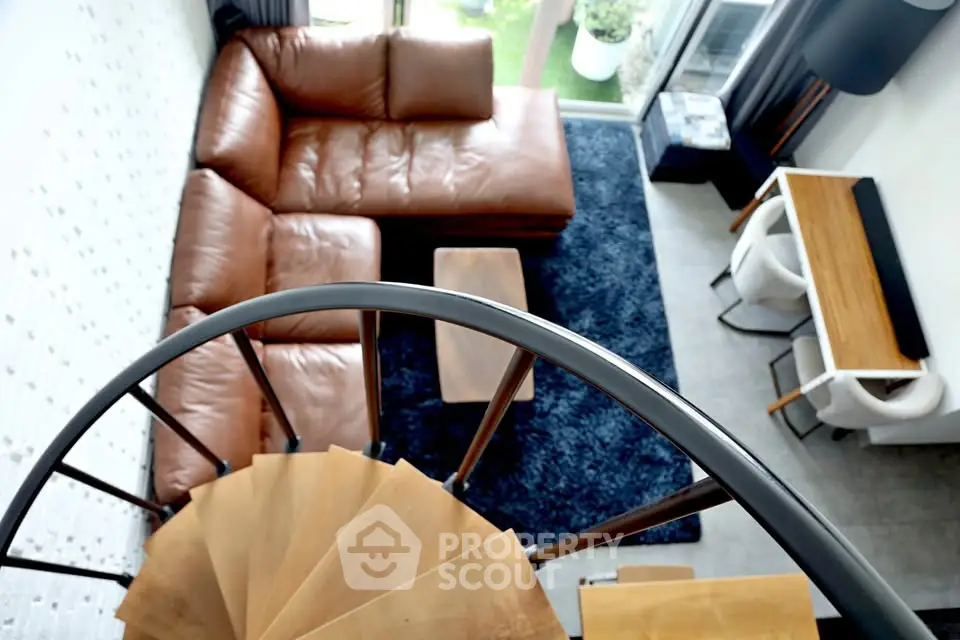 Modern living room with spiral staircase and leather sectional sofa