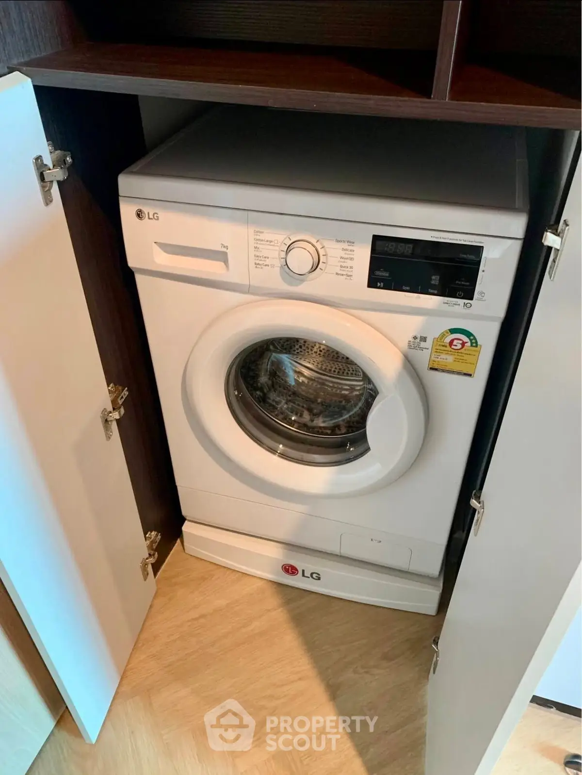 Modern washing machine in sleek cabinet, perfect for efficient laundry in compact spaces.