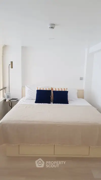 Modern bedroom with cozy bedding and stylish decor in a bright, minimalist design.