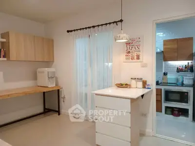 Modern kitchen with open layout, featuring sleek cabinetry and a compact dining island.