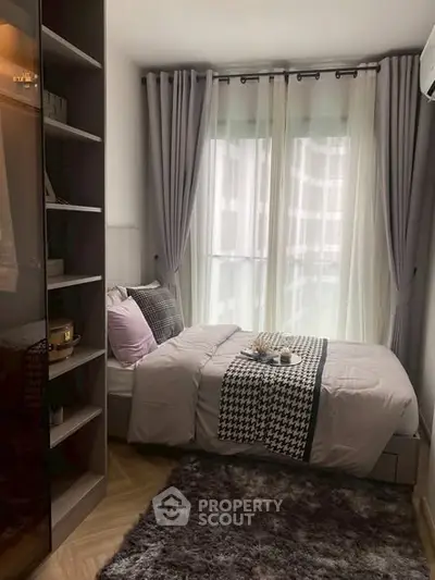 Cozy bedroom with modern decor and large window for natural light