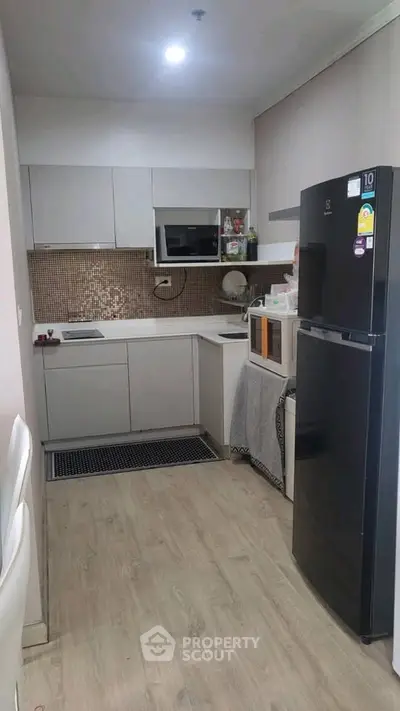 Modern kitchen with sleek appliances and stylish cabinetry in a compact layout.