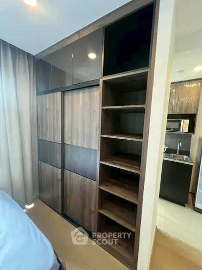 Modern bedroom with sleek built-in wardrobe and adjacent kitchenette