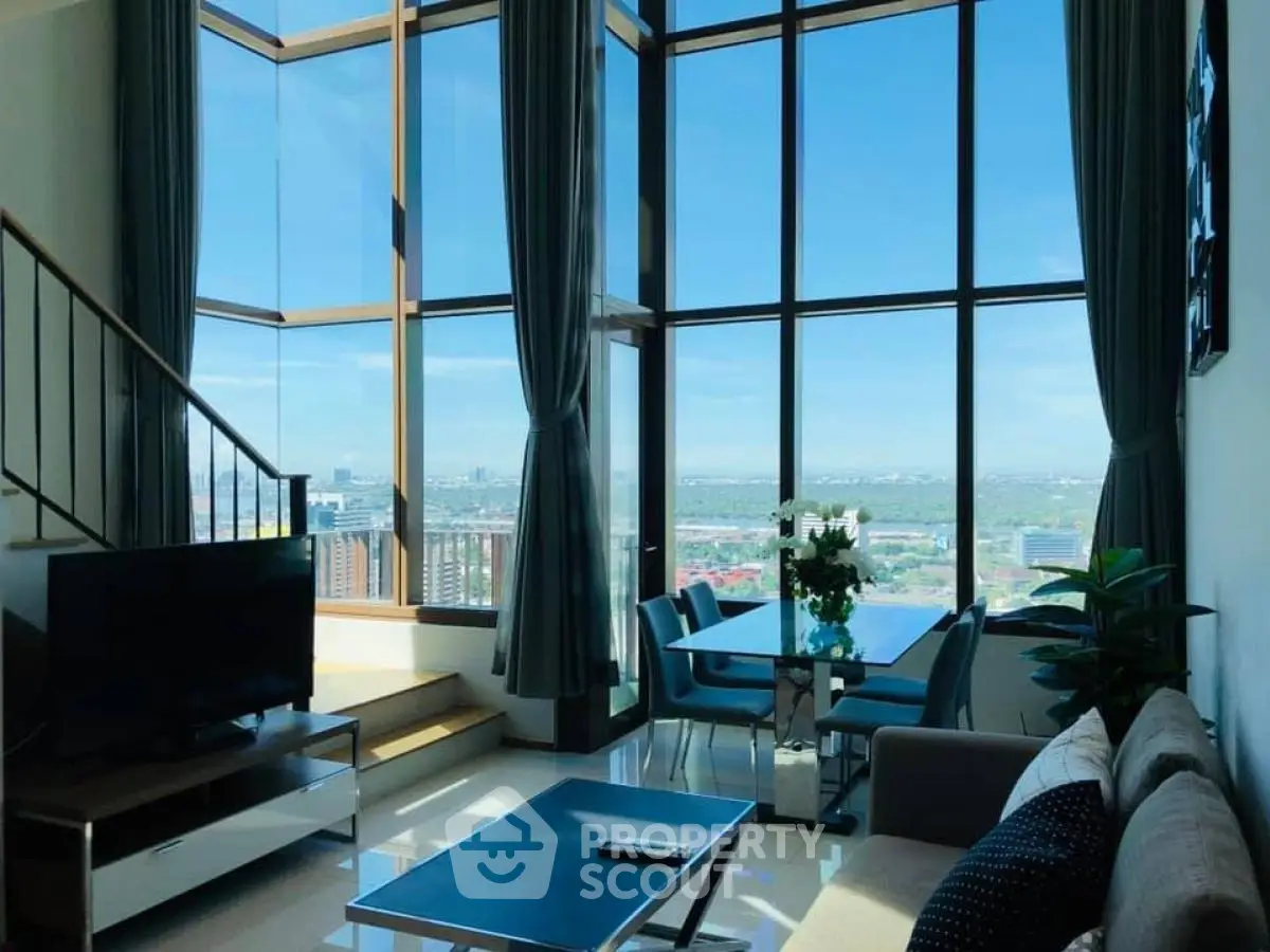 Stunning living room with floor-to-ceiling windows offering panoramic city views and modern decor.