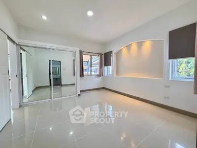 Spacious modern living room with large windows and sleek tile flooring