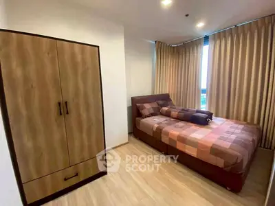 Cozy bedroom with modern wardrobe and large window with curtains.