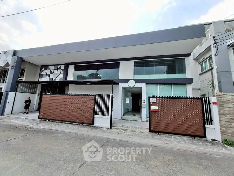Modern townhouse exterior with sleek design and gated entrance in urban setting.