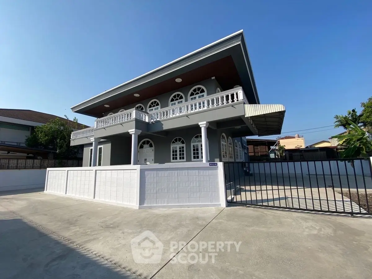 Stunning two-story modern home with elegant balcony and spacious driveway.