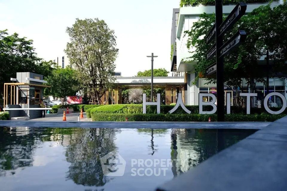 Modern commercial building with lush greenery and reflective water feature