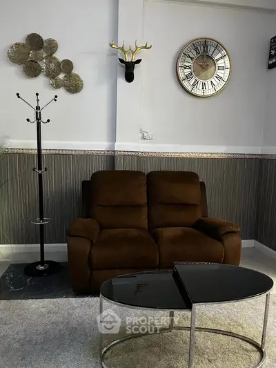 Stylish living room with brown sofa, modern decor, and elegant wall clock, perfect for cozy relaxation.