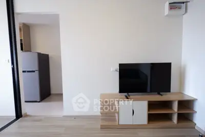 Modern living room with sleek TV stand and adjacent kitchen area