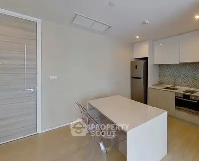 Modern kitchen with sleek design and open layout featuring dining area and appliances.