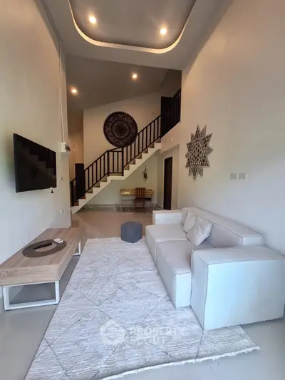 Modern living room with high ceiling, stylish decor, and cozy seating area.