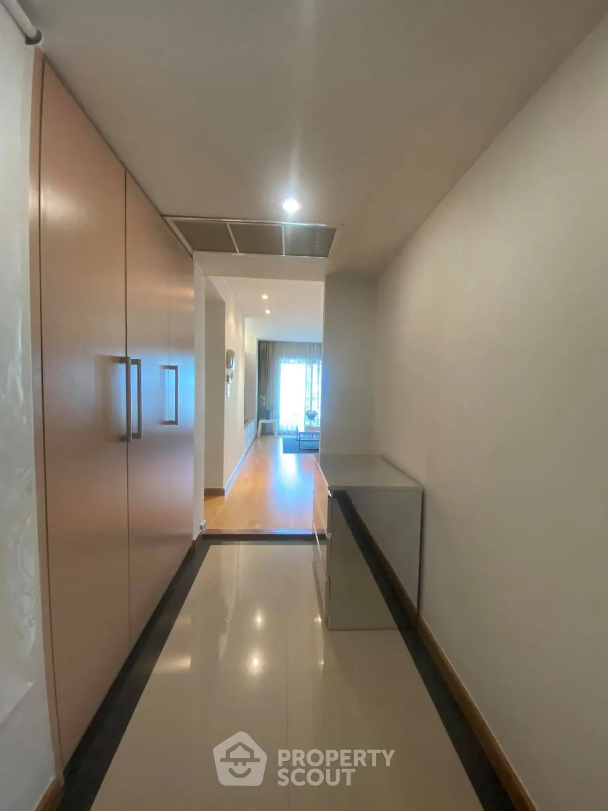 Spacious hallway leading to a bright living area with modern design.