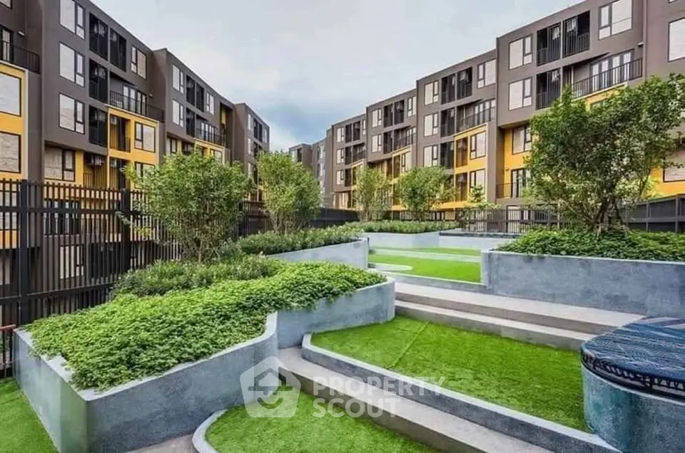 Modern apartment complex with landscaped garden and contemporary architecture.