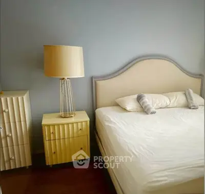 Cozy bedroom with elegant bed and stylish lamp, perfect for relaxation.