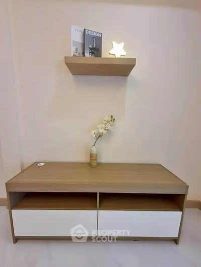 Modern minimalist living room with wooden shelf and decorative items.