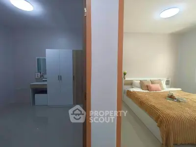 Modern bedroom with cozy decor and adjacent dressing area in a stylish apartment.