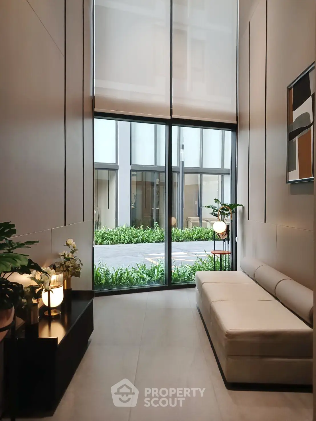 Modern living room with high ceilings and large windows, featuring elegant decor and natural light.