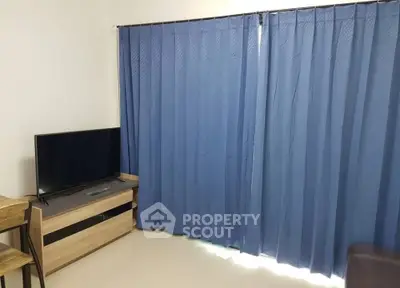 Cozy living room with blue curtains and modern TV setup